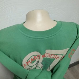 May include: A green sweatshirt with a white graphic print that says "Seaward Rescue" in red letters.