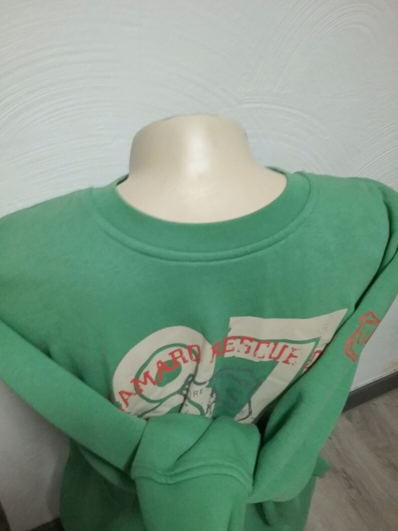 May include: A green sweatshirt with a white graphic print that says "Seaward Rescue" in red letters.