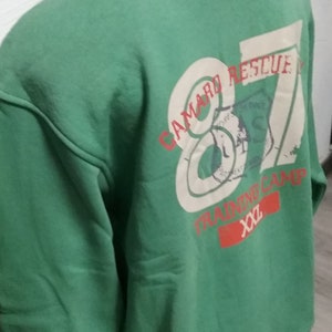 May include: Green sweatshirt with a white graphic print that says "Camaro Rescue 87 Training Camp xx2".