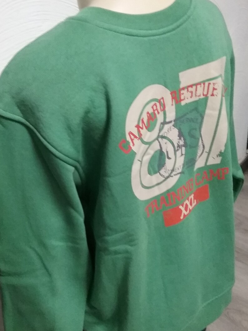 May include: Green sweatshirt with a white graphic print that says "Camaro Rescue 87 Training Camp xx2".