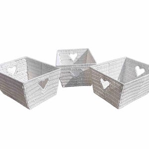 May include: Three white woven rectangular baskets with heart-shaped cutouts. The baskets are made of a textured material and are arranged on a white background. The baskets are of varying sizes.