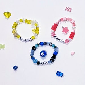 May include: Three colorful beaded bracelets with letter beads spelling out the names "Denji", "Power", and "Aki".
