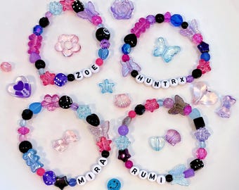 custom HUNTR/X stretchy beaded bracelets (custom COLOR, customer MEMBER rumi mira zoe huntrx)