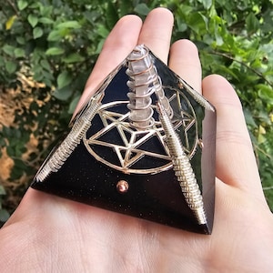 May include: Black obsidian pyramid with a gold wire wrapped pentagram and a clear quartz crystal in the center.