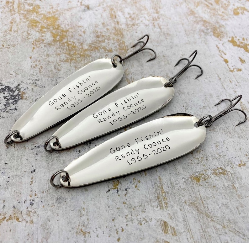 Personalized Gone Fishin’ memorial fishing lures with custom name and years, hand-stamped metal keepsake gifts.