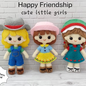 May include: Three felt dolls, each with a different outfit and hairstyle. The dolls are wearing a blue and white outfit, a yellow and blue outfit, and a green and white outfit. The dolls are smiling and have brown eyes. The dolls are labelled "Happy Friendship cute little girls".