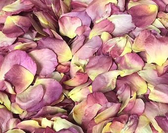 May include: A close-up of a pile of dried rose petals. The petals are a mix of pink and yellow, and they are arranged in a random pattern.