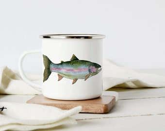 May include: White enamel mug with a silver rim and handle. The mug features a watercolor illustration of a rainbow trout, showcasing green, pink, and blue hues. The mug sits on a small, square wooden coaster.