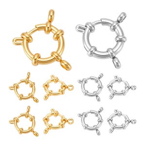 Puede incluir: Una colección de cierres de joyería dorados y plateados. Los cierres son redondos con un diseño de nudo y cuentan con un lazo y una barra para un cierre seguro. La imagen muestra varios tamaños y estilos de estos cierres, adecuados para la fabricación de joyas.
