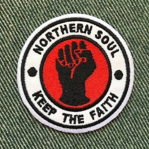 May include: White embroidered patch with a red circle and a black raised fist in the centre. The text "Northern Soul Keep The Faith" is written around the circle.