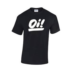 以下が含まれることがあります： 白い「Oi!」の文字がスタイリッシュなフォントで書かれた黒いTシャツ