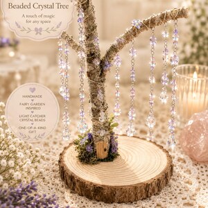 Puede incluir: Una escultura de &aacute;rbol en miniatura con un tronco de corteza texturizada sobre una base de rodaja de madera circular. Las ramas est&aacute;n adornadas con cadenas plateadas colgantes y cuentas de cristal facetadas en tonos morados y transparentes.