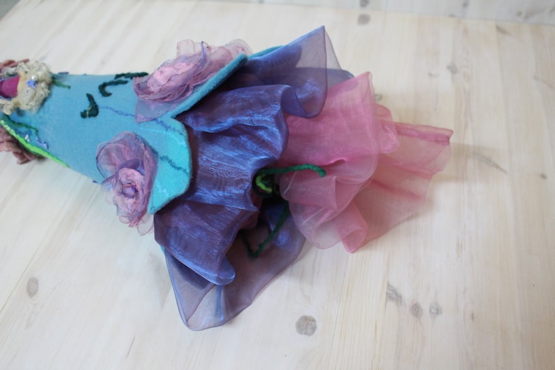 May include: A blue felt cone with pink and purple fabric flowers and layers of pink and purple tulle.