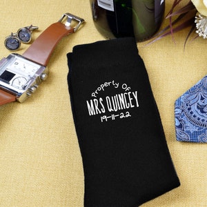 Può includere: Calze nere con ricamo bianco che recita "Property of Mrs. Quincy 19-11-22".