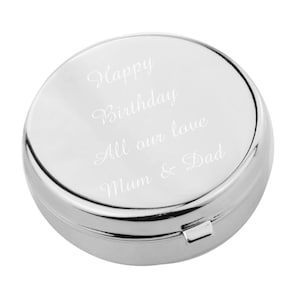 May include: A silver round pill box with an engraved message that reads "Happy Birthday All our love Mum & Dad".