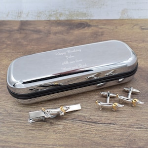 May include: A silver gift box with a personalised message that reads "Happy Birthday John All our love Mum and Dad". The box contains a silver tie clip and cufflinks with a dachshund design.