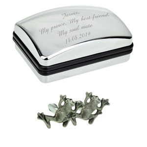 May include: Silver cufflinks in a silver box with a personalized inscription that reads "Jarvis, My prince, My best friend, My soul mate 14.08.2019". The cufflinks are shaped like frogs.