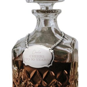 May include: Silver bottle stopper with a chain and a personalized tag that reads "Charlie CHEERS TO 50 YEARS!"