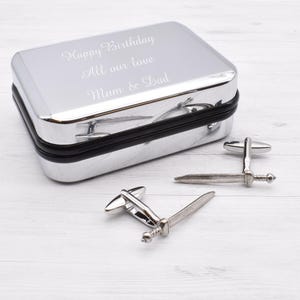 May include: Silver cufflinks in the shape of swords, in a silver gift box with the inscription "Happy Birthday All our love Mum & Dad".