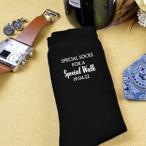 May include: Black socks with white text that reads "Special Socks for a Special Walk 19.04.22".