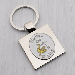 Stilvolles Hooked on Angler-Design mit speziellem personalisierten gravierten Nachrichtenschlüsselring, der in Samtbeutel präsentiert wird
