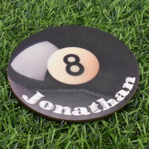 May include: A round, black and white coaster with a white 8-ball and the name "Jonathan" written in white letters.
