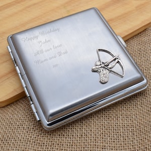 May include: Silver cigarette case with an engraved message that reads "Happy Birthday John All our love Mum and Dad xxx" and a silver archer figurine.