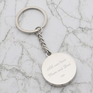 May include: Silver keychain with a round charm that says "All our love Mum and Dad xxx".