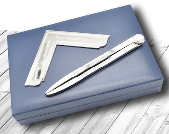 May include: A silver compass and a silver protractor with the text "7588 Eastbrook" engraved on it, both in a blue velvet box.