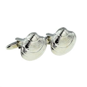 May include: A pair of silver-toned cufflinks featuring a detailed, three-dimensional seashell design. Each cufflink has a polished, reflective surface with visible ridges and a standard hinged toggle mechanism on the back for secure fastening.