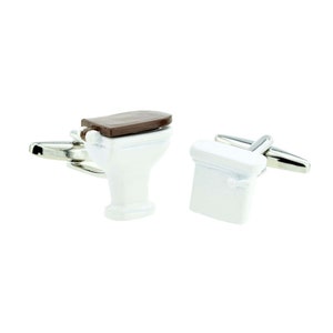 May include: A pair of silver cufflinks with a white toilet design. One cufflink features a closed toilet lid, while the other has a brown toilet seat and lid.