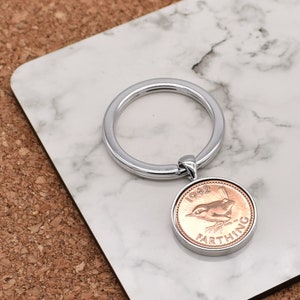 May include: A silver key ring with a 1942 British farthing coin attached. The coin features a wren and the words "1942" and "Farthing".