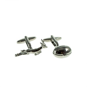 May include: A pair of silver cufflinks, one featuring a stylized leaping antelope and the other a rugby ball.