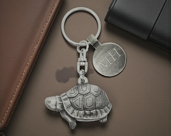 Llavero de tortuga de peltre personalizado, hecho en Inglaterra, presentado en una bolsa de terciopelo.