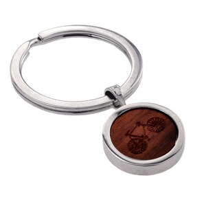 May include: A silver key chain with a round wooden charm featuring a laser-engraved bicycle design.