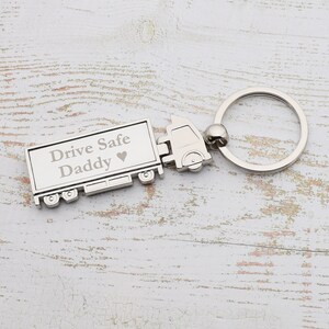 Puede incluir: Llavero de camión plateado con las palabras "Drive Safe Daddy" y un corazón grabado en el lateral.