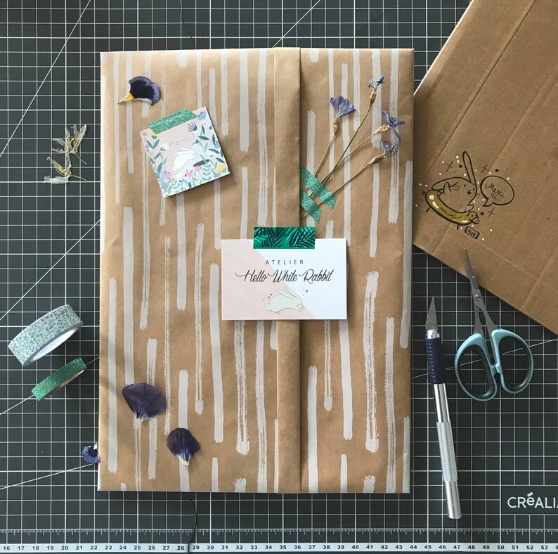 May include: A brown paper gift bag with white stripes, decorated with dried flowers, a small card that says "Atelier Hello White Rabbit", and a small sticker with a rabbit illustration.