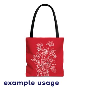 May include: Red tote bag with a white floral design featuring strawberries and flowers. The bag has black handles.