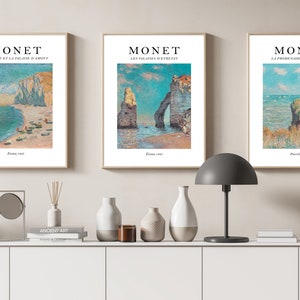 Puede incluir: Tres impresiones enmarcadas de paisajes marinos de Claude Monet. Las impresiones se titulan "La Plage et la falaise d'Amont", "Les falaises d'Etretat" y "La Promenade de la falaise".