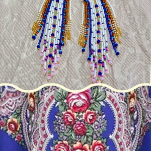 May include: A pair of beaded earrings with a white base, accented with gold, blue, and pink beads. The earrings have a long fringe design. Below, a blue floral shawl with red roses and a fringe.
