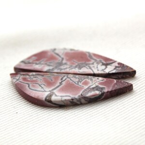 May include: Two teardrop-shaped cabochons featuring a deep mauve and reddish-brown base color with intricate, dark gray to black veining patterns running throughout the surface of the stones, displaying a smooth, polished, and flat top finish.