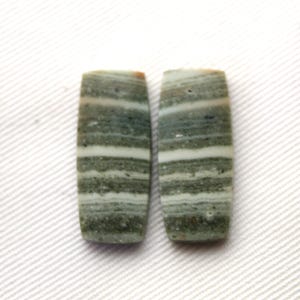 May include: Pair of green and white striped rectangular cabochons. The cabochons are smooth and polished.
