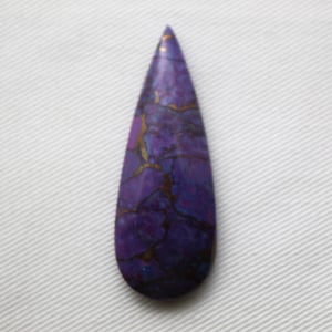 May include: A teardrop-shaped gemstone with a deep purple hue, veined with gold and darker purple inclusions. The polished stone has a smooth surface and a pointed top, set against a white background.