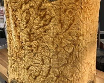 May include: A gold lampshade with a fuzzy, textured fabric and a gold trim. The lampshade has a scalloped bottom edge.