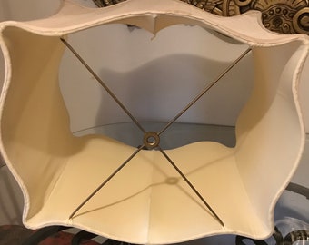 May include: A white lampshade with a scalloped edge and a metal frame. The frame is visible through the fabric.