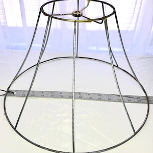 May include: A silver metal lampshade frame with a brass center ring. The frame is 14 inches in diameter.