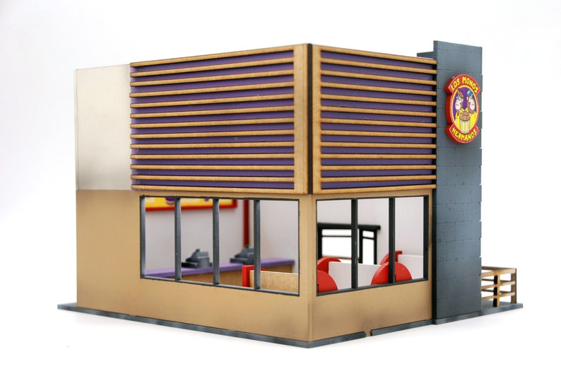 K&ouml;nnte beinhalten: Ein Miniaturmodell eines Fast-Food-Restaurants mit brauner und violetter Fassade. Das Restaurant hat ein gro&szlig;es Fenster mit Blick auf das Innere. Das Schild &uuml;ber dem Eingang lautet "Los Pollos Hermanos".