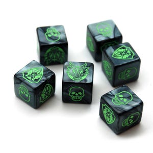 Può includere: Sei dadi neri e grigi con illustrazioni verde neon di teschi e altri simboli. I dadi sono sparsi su una superficie bianca, ognuno con un design diverso.