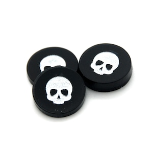 May include: Three black round buttons with a white skull design.