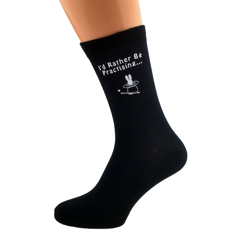 K&ouml;nnte beinhalten: Schwarze Socken mit einer wei&szlig;en Hasenillustration und dem Text "I'd Rather Be Practising..."